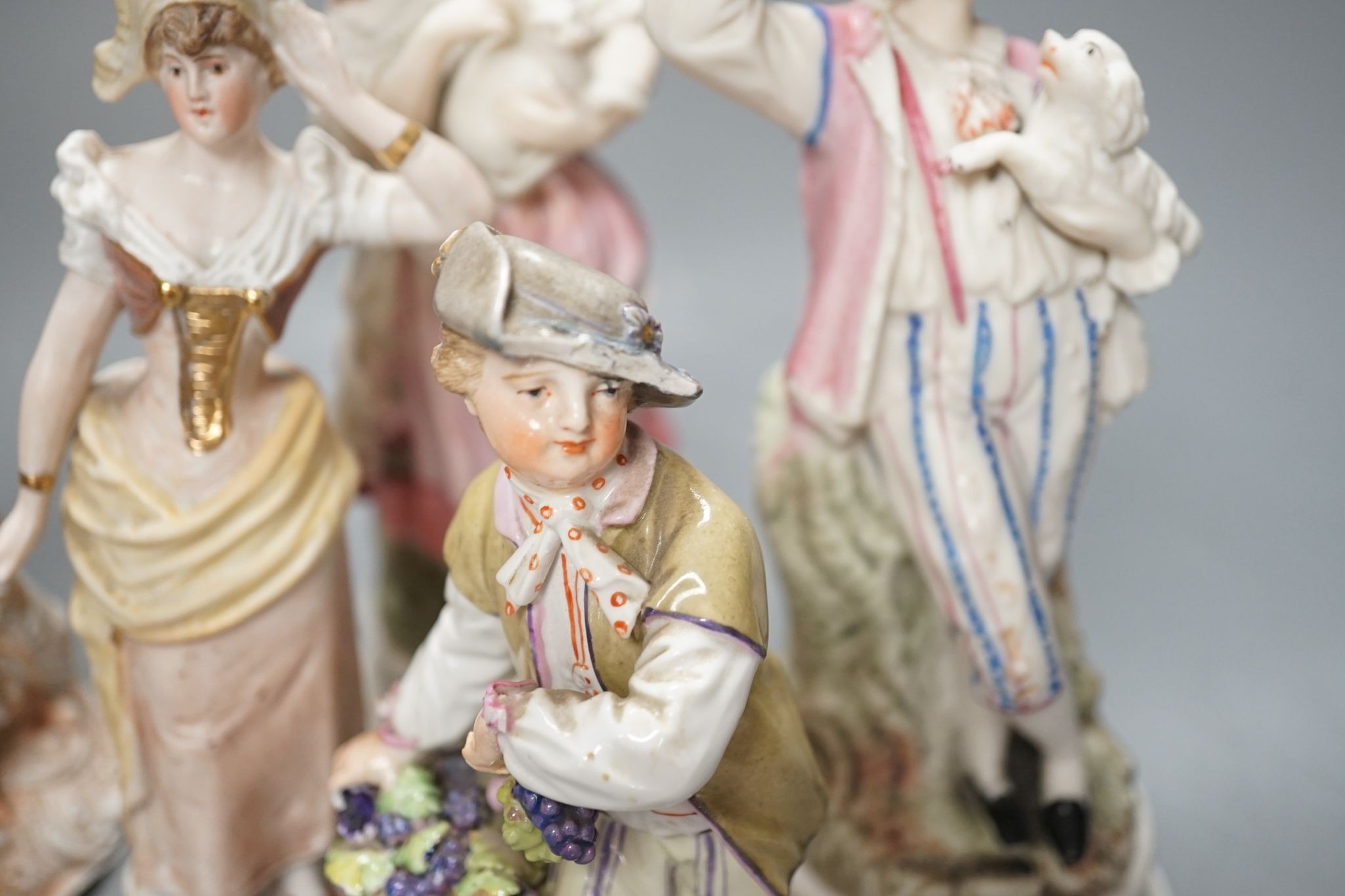 Ten French bisque figures and a Berlin figure of a grape picker, tallest 19cms high.